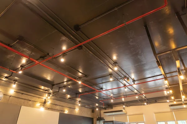 Ceiling of industry factory with lights in office building. System work with pipe lines. Loft style.