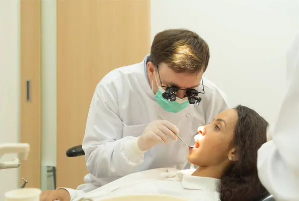 Tandläkare Kollar Den Latinska Kvinnans Tänder Med Tandläkarspegel Sjukhuskliniken Tänder — Stockfoto