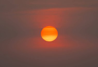 Günbatımı gökyüzü olan güneş. Soyut doğa geçmişi. Alacakaranlık vakti turuncu renkli bulutlarla dramatik mavi.