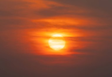 Günbatımı gökyüzü olan güneş. Soyut doğa geçmişi. Alacakaranlık vakti turuncu renkli bulutlarla dramatik mavi.