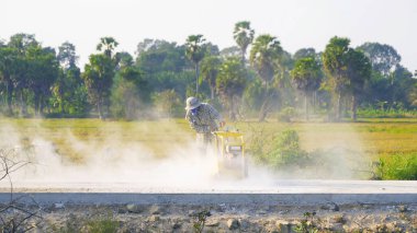 İnsanlar inşaat halindeki dumanla yol ya da cadde kazıyor, şehir merkezinde ulaşım konseptinde bir makine kullanıyorlar. Motor çalışıyor..