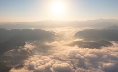 Orman ağaçlarının ve deniz sisi, sis ve bulutlu yeşil dağ tepelerinin havadan görünüşü. Doğa manzarası arka planı, Tayland.