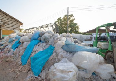 Çevre kirliliği kavramının kentsel alanındaki farklı türde çöp yığını, plastik torbalar, şişeler ve çöp bidonları içeren fabrika endüstrisi.