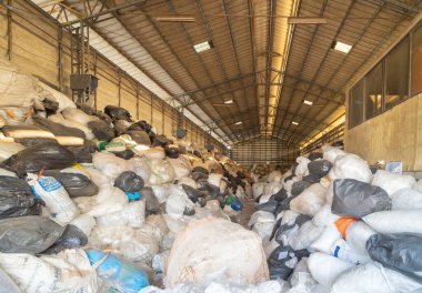 Çevre kirliliği kavramının kentsel alanındaki farklı türde çöp yığını, plastik torbalar, şişeler ve çöp bidonları içeren fabrika endüstrisi.