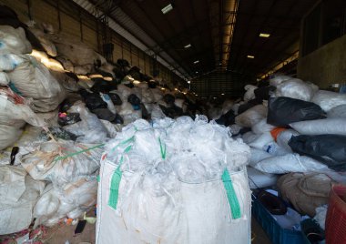 Çevre kirliliği kavramının kentsel alanındaki farklı türde çöp yığını, plastik torbalar, şişeler ve çöp bidonları içeren fabrika endüstrisi.