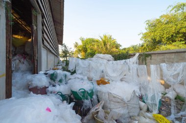 Çevre kirliliği kavramının kentsel alanındaki farklı türde çöp yığını, plastik torbalar, şişeler ve çöp bidonları içeren fabrika endüstrisi.