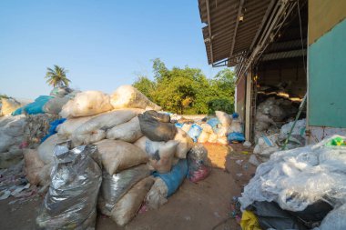 Çevre kirliliği kavramının kentsel alanındaki farklı türde çöp yığını, plastik torbalar, şişeler ve çöp bidonları içeren fabrika endüstrisi.