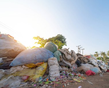 Çevre kirliliği kavramının kentsel alanındaki farklı türde çöp yığını, plastik torbalar, şişeler ve çöp bidonları içeren fabrika endüstrisi.