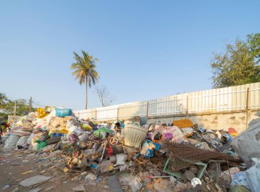 Çevre kirliliği kavramının kentsel alanındaki farklı türde çöp yığını, plastik torbalar, şişeler ve çöp bidonları içeren fabrika endüstrisi.