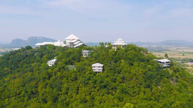 Tayland köyünün havadan görünüşü, yeşil dağ tepelerinde orman ağaçları, Ratchaburi, Tayland. Seyahat ve tatilde doğa manzarası.
