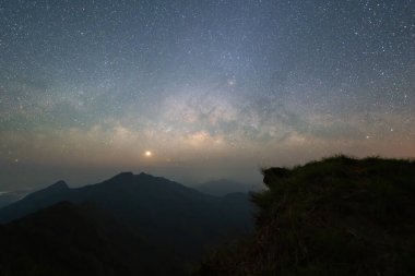 Doi Tung, Chiang Rai, Tayland dağ tepeleri, gece mavi gökyüzünde parlak yıldızlı Samanyolu. Doğal evren uzay manzarası arka planı. Bu galaksi bizim güneş sistemimizi içerir.