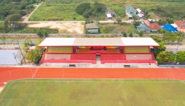 Lastik zeminin havadan görünüşü, tribünlü bir spor stadyumunda kırmızı koşu pisti. Spor ve eğlence geçmişi.