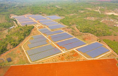 Çiftlikteki çatıdaki güneş panelleri veya güneş pillerinin havadan görüntüsü. Yeşil alanı olan bir enerji santrali, yenilenebilir temiz enerji kaynağı. Sanayide elektrik enerjisi için eko teknoloji.