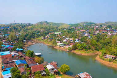 Mon köyündeki yerleşim yerlerinin havadan görünüşü, göl veya nehir ile doğa ağaçları, Kanchanaburi, Tayland, Asya 'daki kentsel şehir kasabası, binalar.