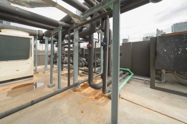 Chiller tower or cooling tower on rooftop of a office building in urban city. System work. Architecture machine. Condenser Water Supply and Condenser Water Return pipe lines. Ventilation compressor.