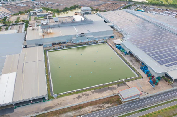 Aerial top view of industry factory in urban city town. Inventory import and export business commercial, Automobile and automotive industry distribution logistic transport with lake and river.