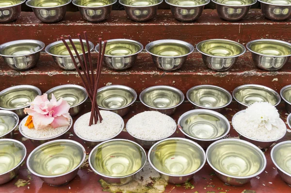 Cuencos pequeños con agua y arroz alrededor de un templo —  Fotos de Stock