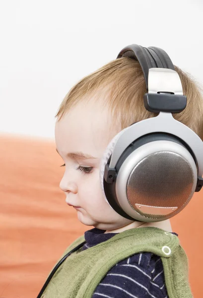 Young child on couch with headphone — Stock Photo, Image