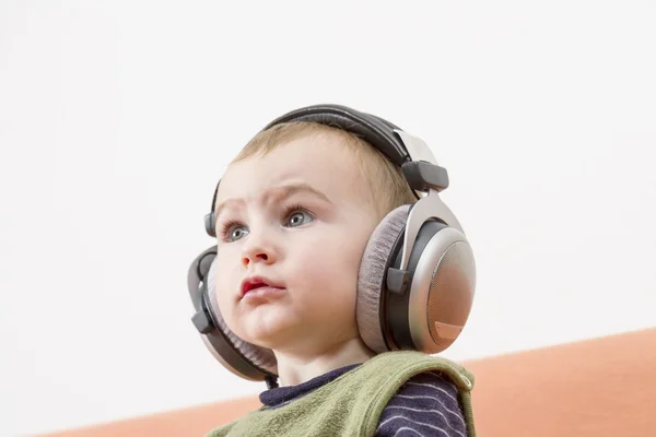 Маленька дитина на дивані з навушниками — стокове фото