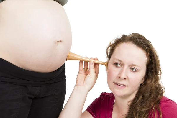 Midwife listening at human belly — Stock Photo, Image