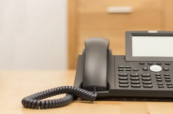 Teléfono en el escritorio con fondo borroso — Foto de Stock