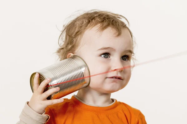 Criança pequena ouvindo lata pode telefone — Fotografia de Stock