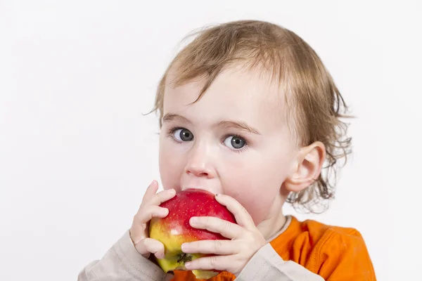 Niño pequeño comiendo manzana roja — Foto de Stock