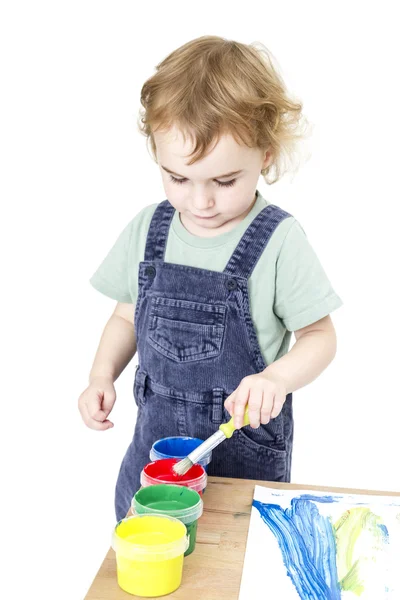 Criança com escova e pintura em fundo branco — Fotografia de Stock