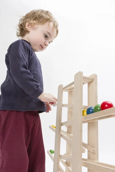 Criança brincando com caminho de bola de madeira — Fotografia de Stock