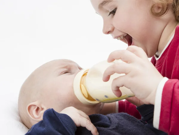 Kleinkind füttert Kleinkind mit Milchflasche — Stockfoto