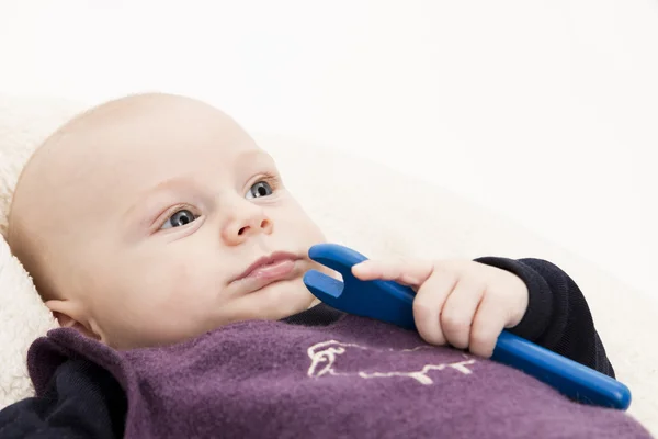 Newborn baby with blue wooden toll — Stock Photo, Image