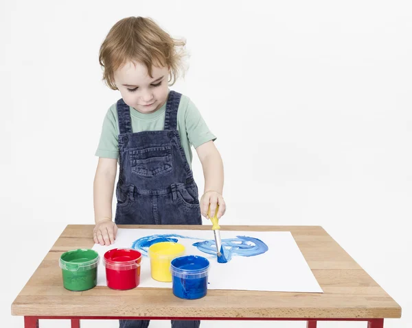 Sevimli kız küçük masanın üzerinde boyama — Stok fotoğraf