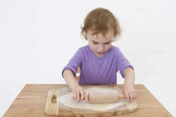 Cute curly child rolling out dough — Stock Photo, Image