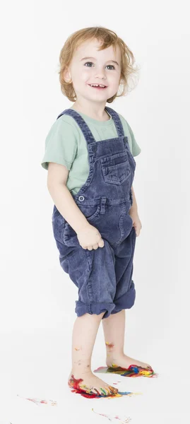 Kind met geschilderde voeten houden broek — Stockfoto