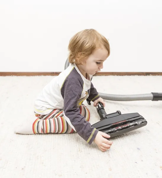 Young child cleaning vacuum cleaner — Stock Photo, Image