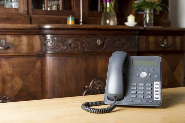 Telefon på träbord i vardagsrum — Stockfoto