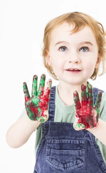 Cute little girl with finger paint looking up — Stock Photo, Image