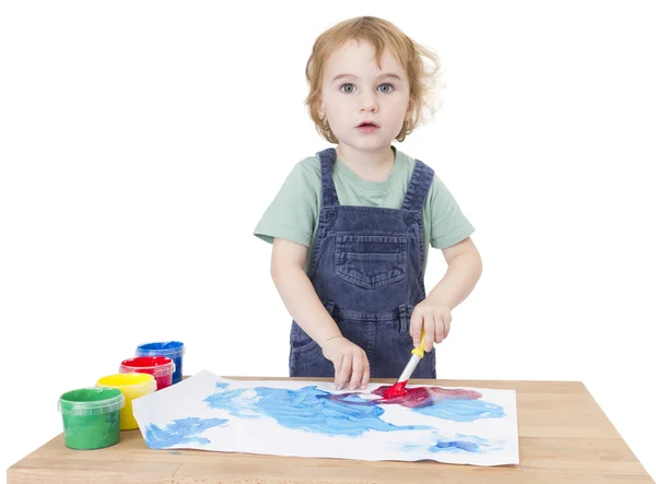 Cute girl painting on small desk looking to camera — Stock Photo, Image