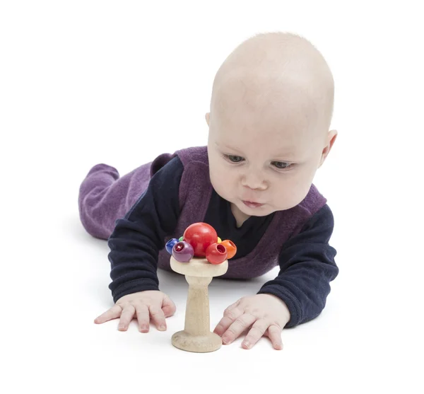 Ребенок смотрит на деревянную игрушку — стоковое фото