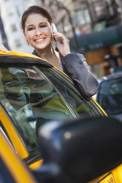 Mladá žena mluví na mobil žluté taxi — Stock fotografie