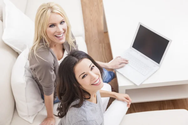 Duas mulheres jovens usando computador portátil em casa no sofá — Fotografia de Stock