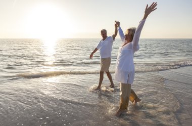 Happy Senior Couple Holding Hands Sunset Sunrise Beach clipart
