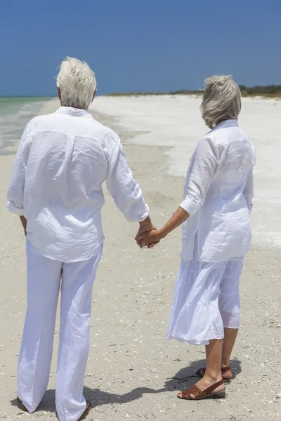 Szczęśliwa para starszy trzymając się za ręce na tropikalnej plaży — Zdjęcie stockowe