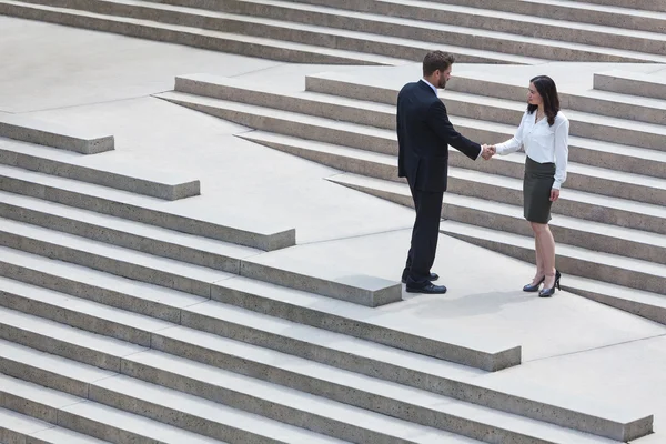 Asiatique femme caucasien homme d'affaires poignée de main ville étapes — Photo