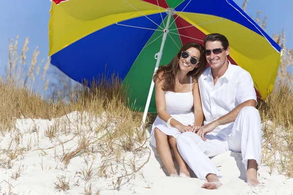 Adam kadını çift güneş gözlüğü çok renkli plaj şemsiye — Stok fotoğraf