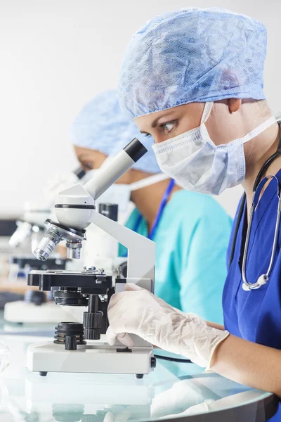 Equipe de pesquisa de cientistas do sexo feminino usando microscópios em laboratório — Fotografia de Stock