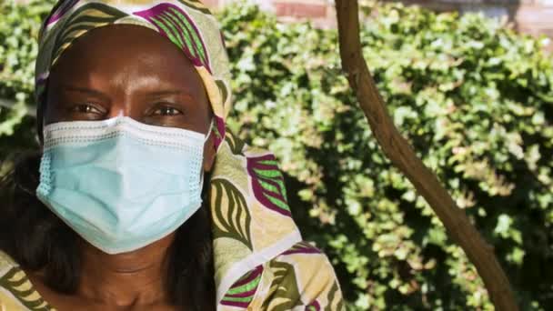 アフリカのCovid 19コロナウイルスパンデミックの際には 伝統的な衣服とフェイスマスクを着用しないアフリカの中年女性 — ストック動画