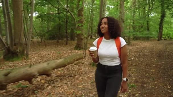 Teenager Afroamerikanerin Wandert Mit Orangefarbenem Rucksack Smartwatch Und Kaffeetasse Wald — Stockvideo