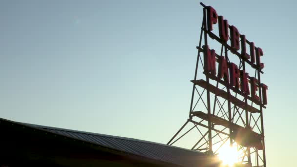 米国ワシントン州シアトルのパイクプレイス市場で公共市場の看板の後ろに沈む太陽の4Kビデオ — ストック動画