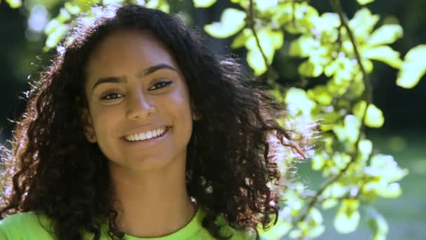 美丽的混血非洲裔美国女孩出生时 年轻女子站在树下笑着 笑着和外面的头发玩耍 — 图库视频影像